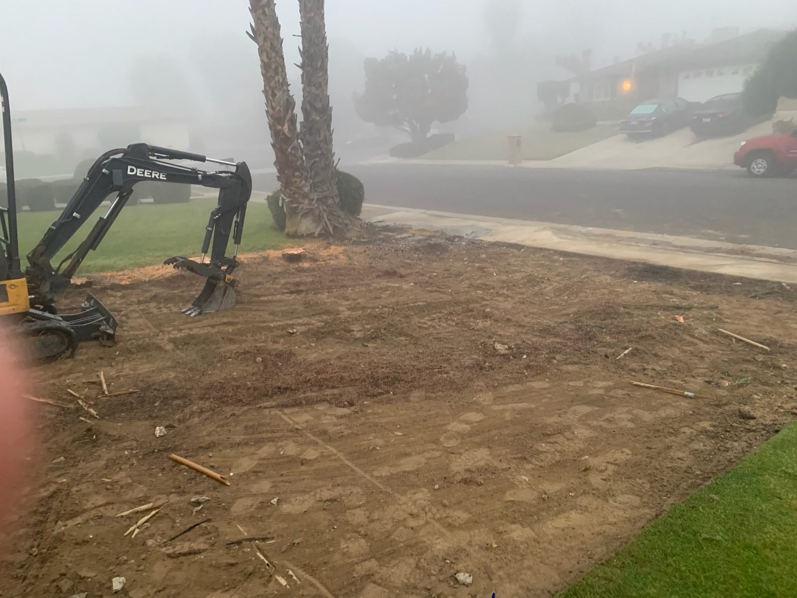 Mini excavator clearing a lawn