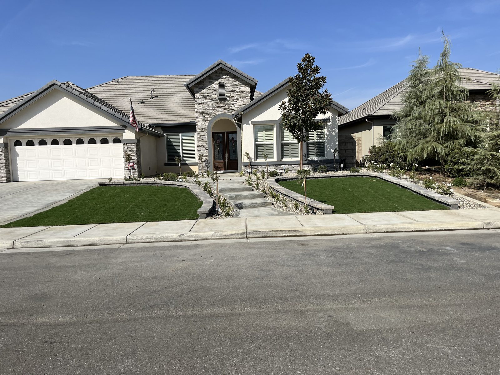 Front yard with artificial turf and stone-accented entry