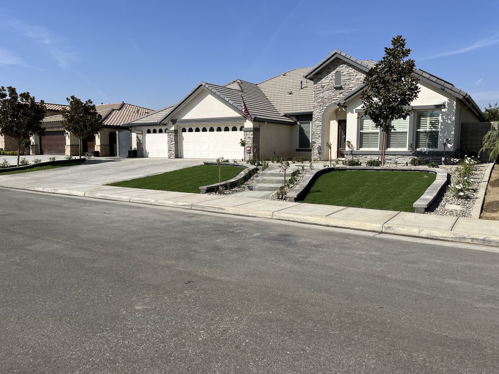 Front yard with stone steps, curbing, and fresh lawn
