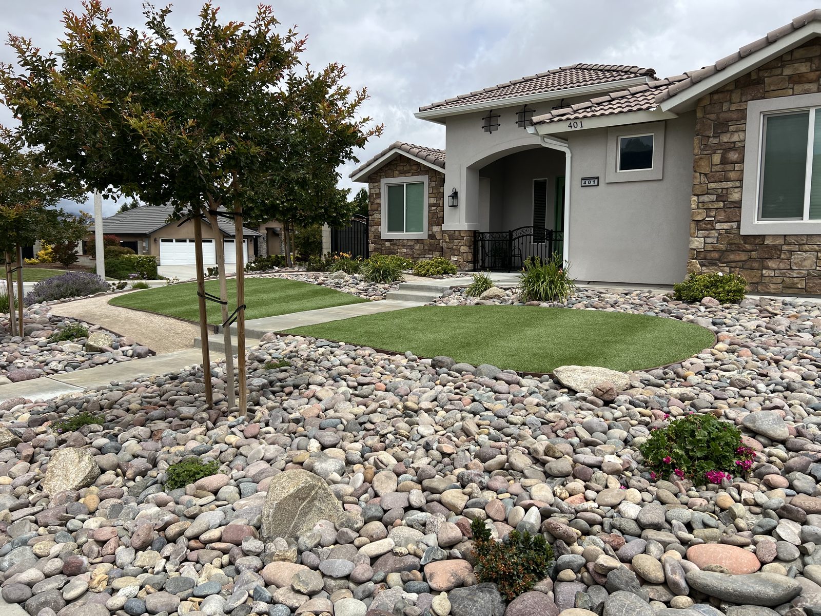 Front yard with turf and river rock beds