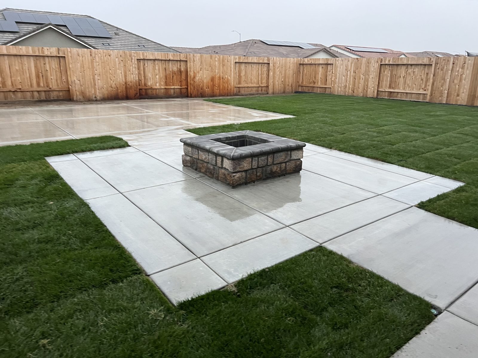 New sod with concrete pads and stone fire pit